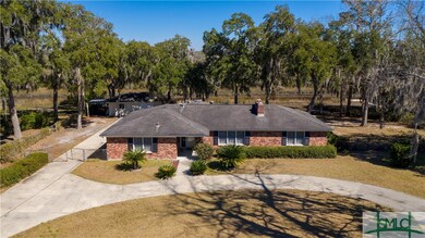 Front of home surrounded by live oaks