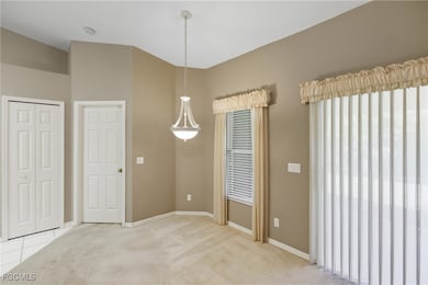 Unfurnished dining area featuring light carpet and baseboards
