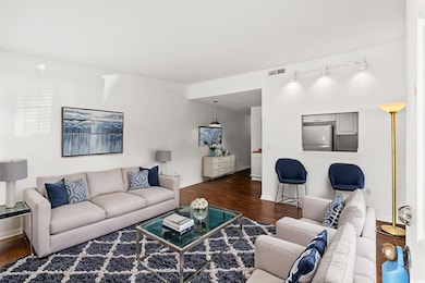 Living area featuring dark wood-style flooring and rail lighting AND VIRTUAL STAGING