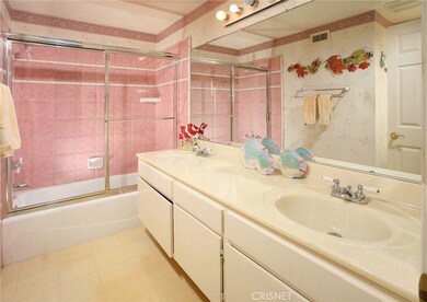 2 guest bathrooms; one with dual vanity and integrated basins, a large dressing mirror, glass enclosed tub/shower and easy care flooring.