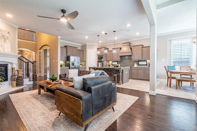 Living room with arched walkways, crown molding, a ceiling fan, dark wood-style floors, and recessed lighting