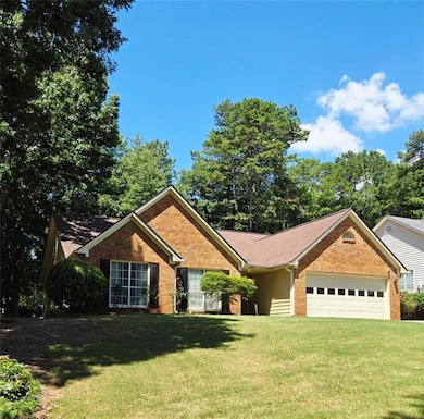 Ranch-style home with an attached garage, brick siding, and a front lawn
