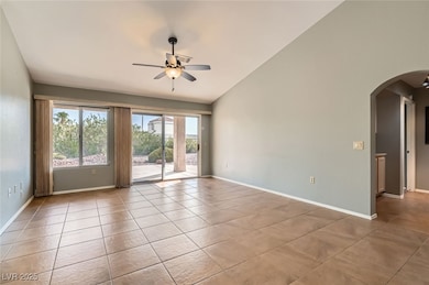 room featuring arched walkways, ceiling fan, vault