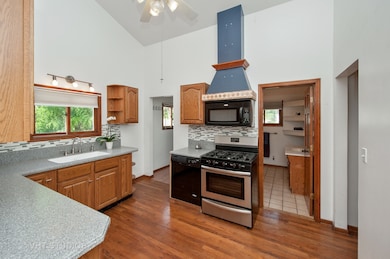 HARDWOODS EXTEND INTO THE KITCHEN WITH VAULTED CEL