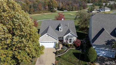 View of subject property with a tree filled landscape and a local golf course