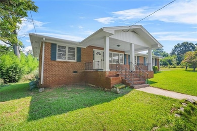 Bungalow-style house featuring a front lawn, brick siding, and covered porch