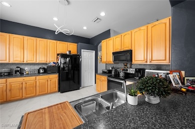 Kitchen with black appliances, tasteful backsplash