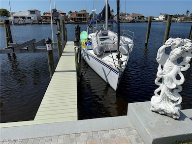Dock area with a water view, boat lift, and a resi