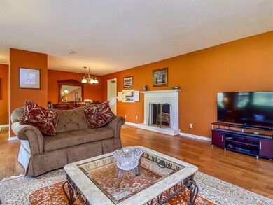 Living room has an open floor plan into the dining area and an electric fireplace.