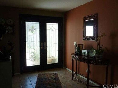 Tiled front entry with stunning glass doors.