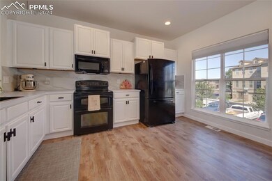 Kitchen featuring LVT flooring, black appliances, 