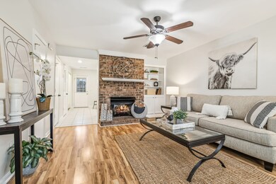 All Fresh Paint! Living Area with Brick Fireplace and Bay Window plus custom cabinets.
