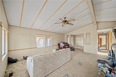 Carpeted living area featuring ceiling fan