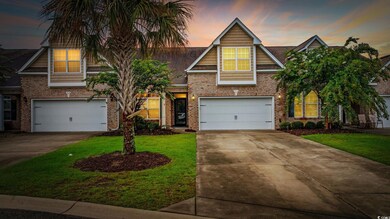 View of front of house featuring a garage, driveway, brick siding, and a yard