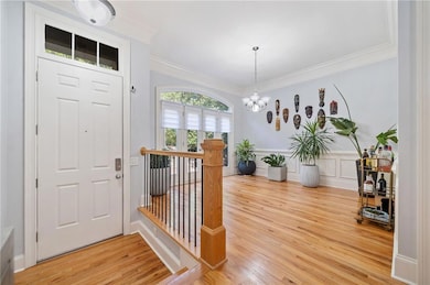 Foyer with ornamental molding, an inviting chandel