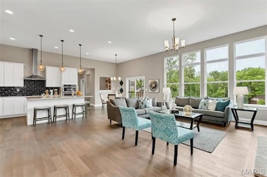Living area featuring a chandelier, light wood-style floors, and recessed lighting