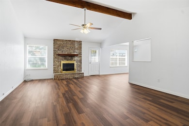 The living room is large and features wood-like floors and a beautiful fireplace.