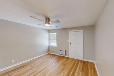Unfurnished room with light hardwood / wood-style floors, an AC wall unit, and ceiling fan