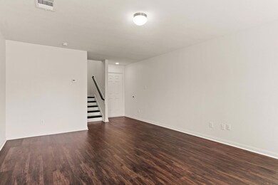 Spare room featuring stairway, baseboards, dark w
