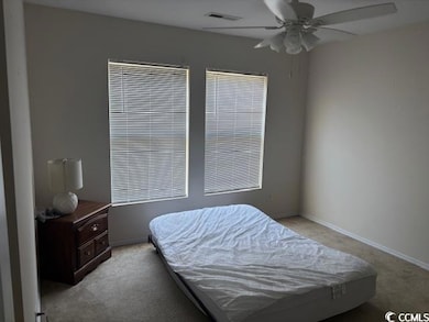 Bedroom with light colored carpet and a ceiling fan