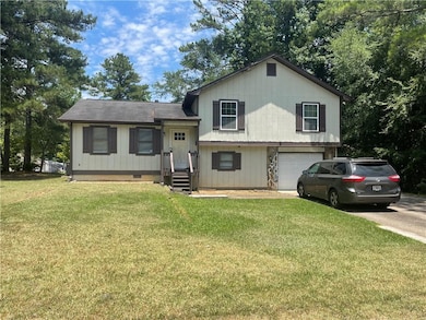 Split level home with a garage and a front yard