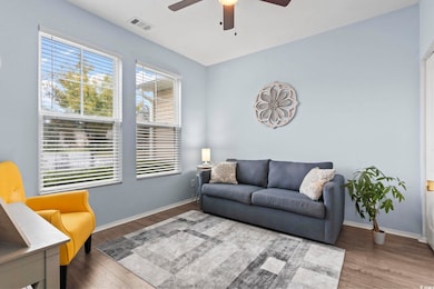 Living area with wood finished floors and a ceiling fan