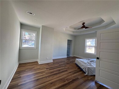 Unfurnished bedroom featuring a tray ceiling, mult
