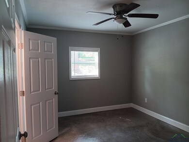 Spare room with baseboards, concrete floors, ceili
