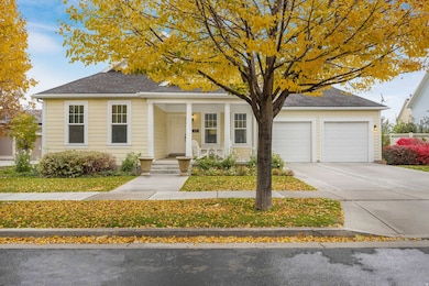 View of front facade featuring concrete driveway, covered porch, an attached garage, and roof with shingles