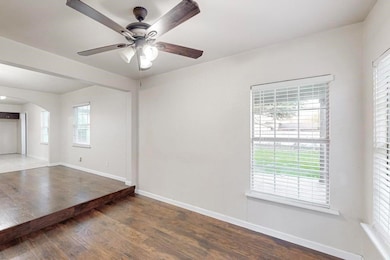 Unfurnished room with ceiling fan and dark hardwoo