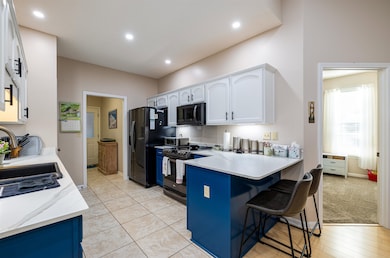 Kitchen with black appliances, light tile patterne