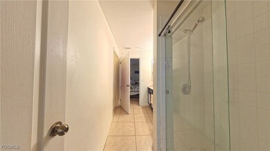 Full bathroom with a stall shower, light tile patterned floors, vanity, and ensuite bathroom