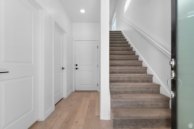 Stairway featuring hardwood / wood-style floors and recessed lighting