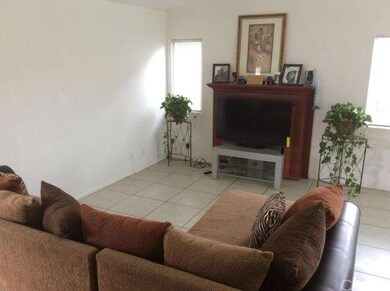 LIVING ROOM WITH WALL TO WALL CERAMIC TILE.