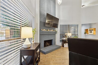 Living room with a brick fireplace and hardwood / 