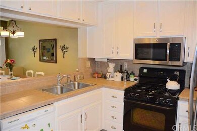 With its white cabinetry, tiled countertops,and pa