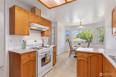 View looking from kitchen out the front window and kitchen with eating space.