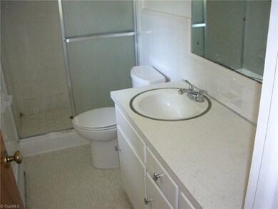 Here you are looking at the master bath that has a shower with a glass door. You also have tile flooring and a window for natural lighting.