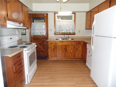 All appliance Kitchen with laminate floors and kno