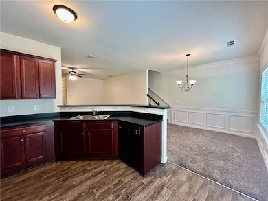 Kitchen with dishwasher, a sink, a chandelier, a ceiling fan, and crown molding