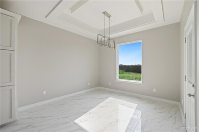 Spare room with light marble finish flooring, a chandelier, a raised ceiling, and baseboards