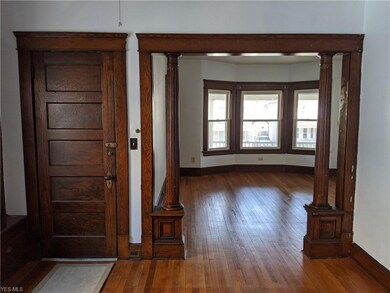 The living room is just through the beautiful stained wood columns. Wood floors run throughout the living space.