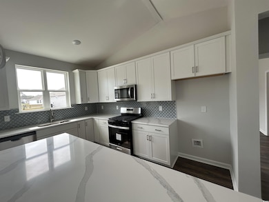 Kitchen featuring tasteful backsplash, lofted ceil