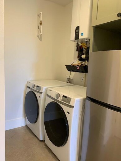 Laundry area with water heater and independent washer and dryer