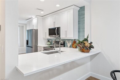 Kitchen with visible vents, stainless steel appliances, and white cabinets