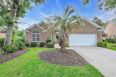 View of front of property with concrete driveway, brick siding, an attached garage, and a front lawn