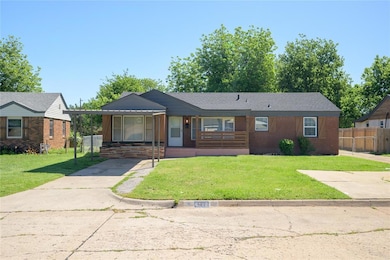 View of front of house with a porch, concrete driveway, an attached carport, and brick siding