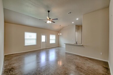 Unfurnished living room with concrete flooring, ceiling fan, and vaulted ceiling