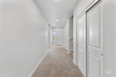 Hallway featuring light colored carpet, recessed lighting, and stairs