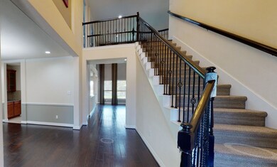 View from the foyer of the wrought iron staircase and soaring ceilings.